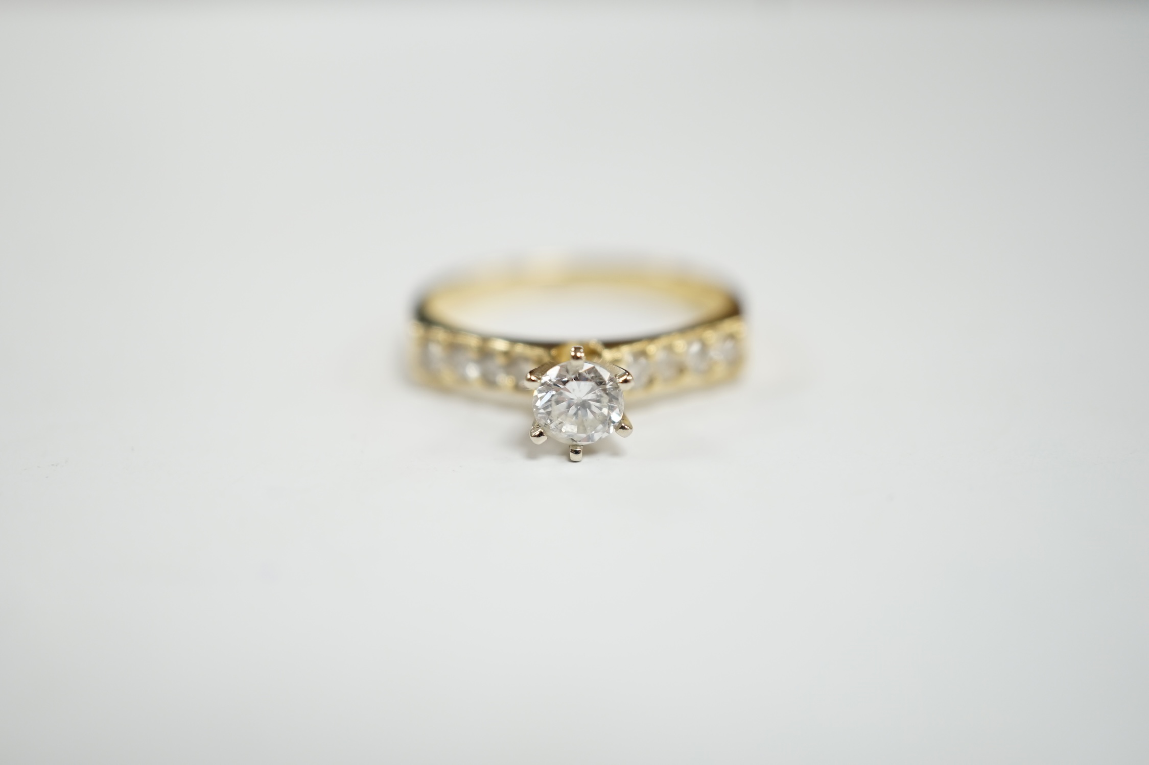 A modern 14k and single stone diamond set ring, with diamond chip set shoulders, size M, gross weight 2.7 grams.